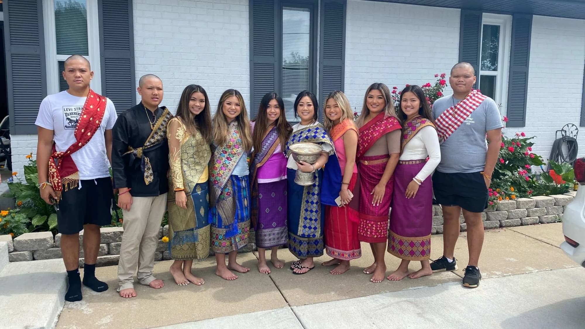 Angel Phommachan, fifth from left in all purple, with family and cousins in traditional Lao dress for a Lao ceremony