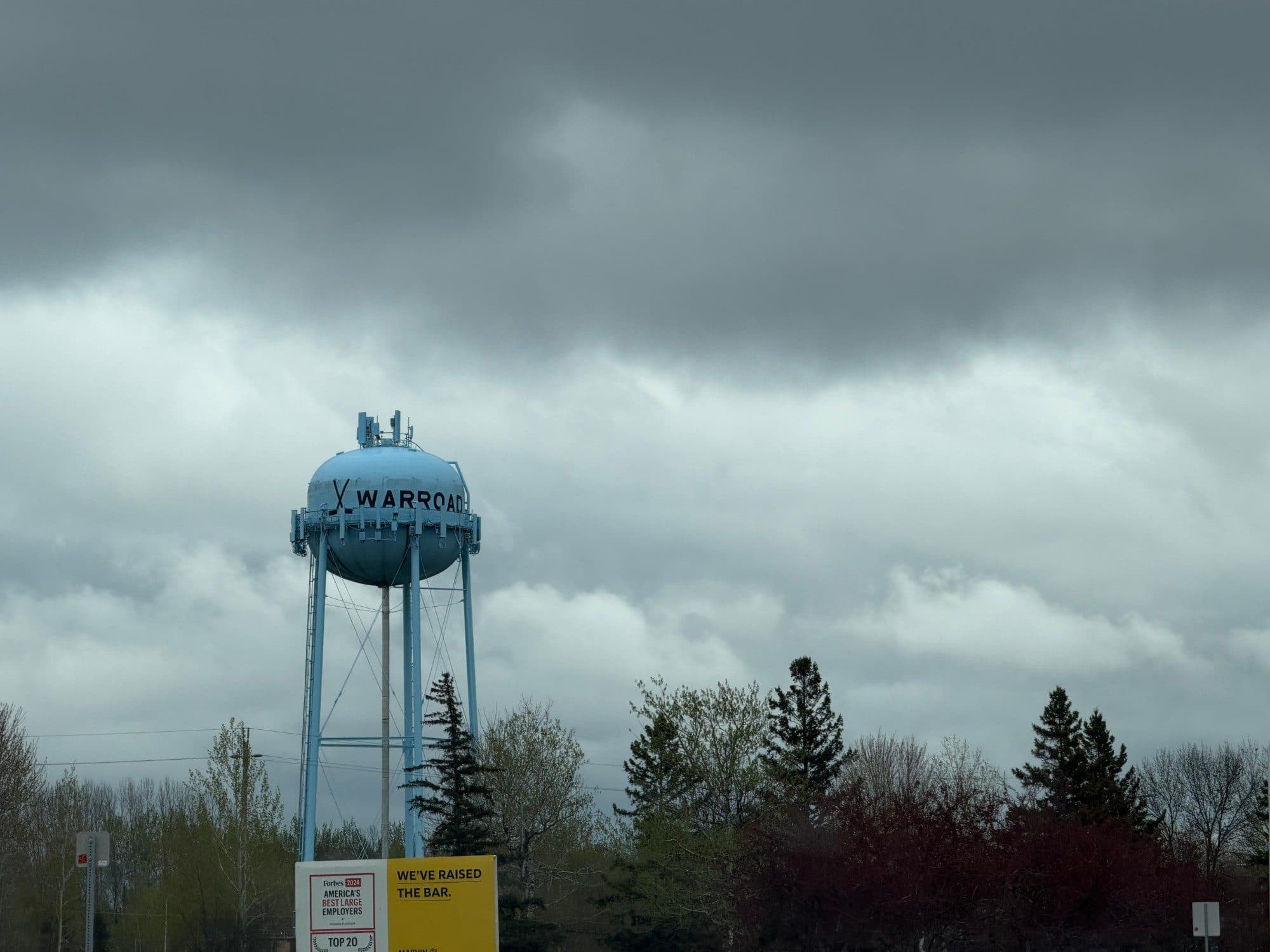 The pale blue Warroad water tower under heavy gray clouds in Warroad, Minnesota