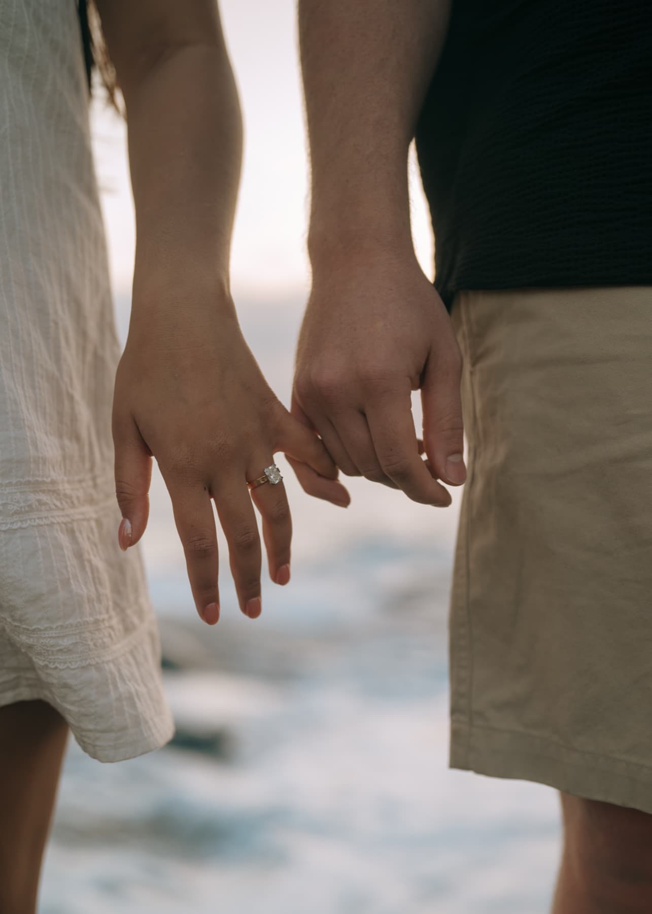 Engaged couple's hands, pinky-linked