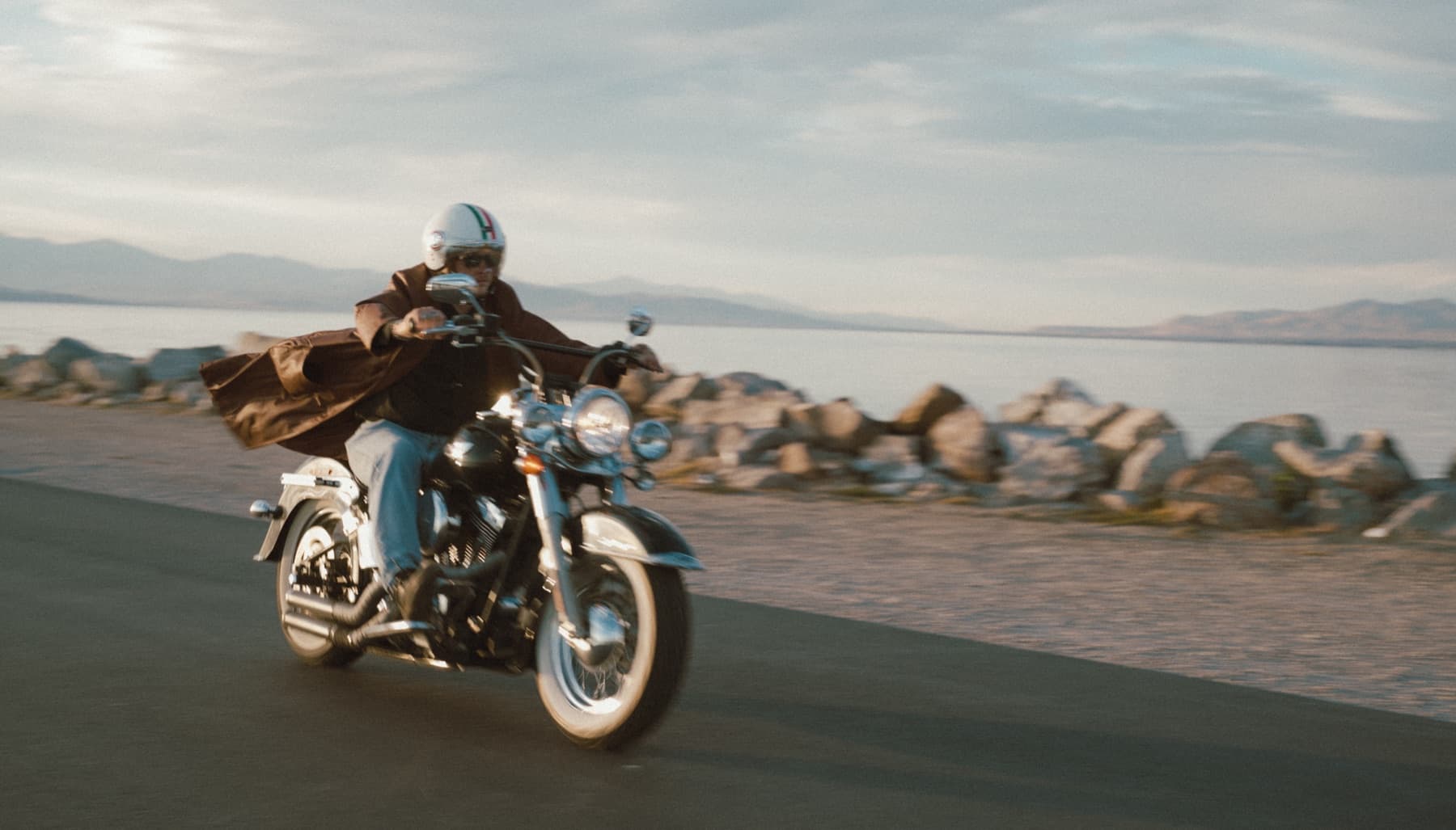 Rider on a motorcycle along a lake road
