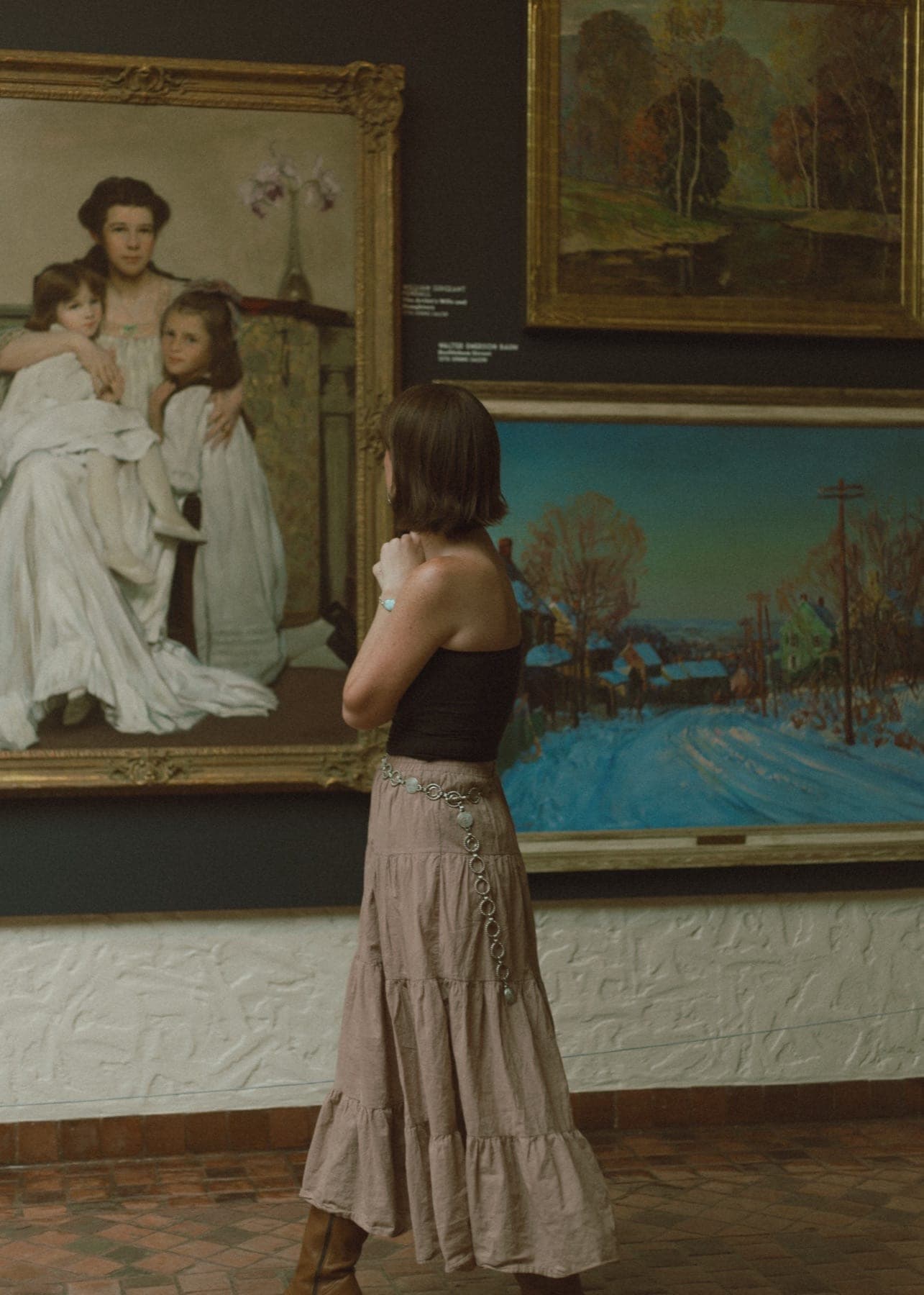 Woman looking at paintings in a gallery