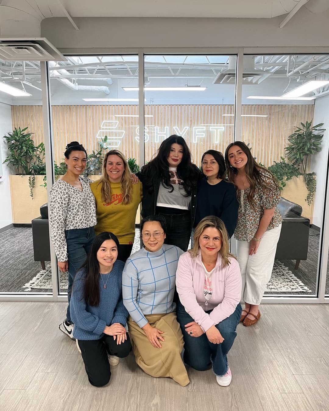 Group photo of seven women in an office